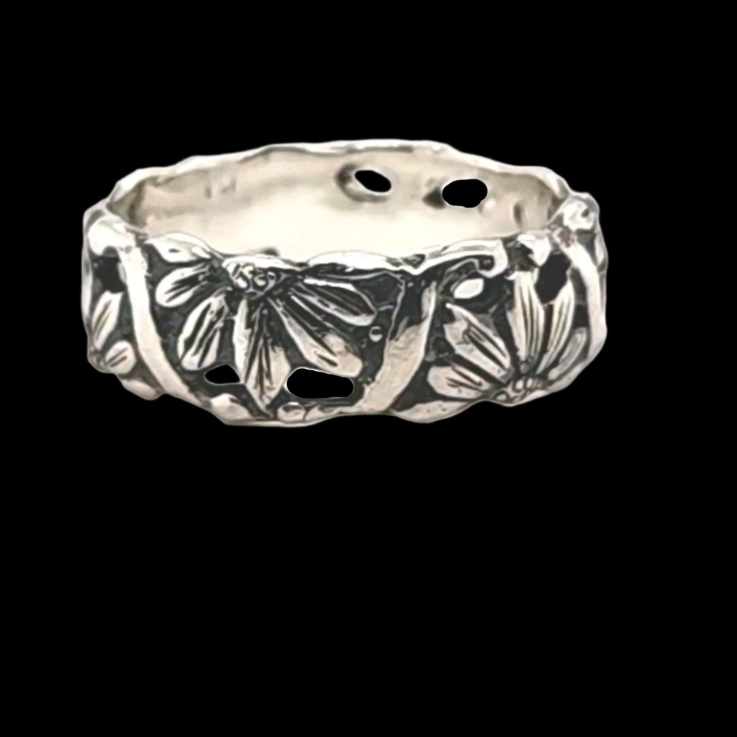 Silver ring with floral design on a black background. Halfs of Daisies alternate facing up and down representing the duality of life, love and the natural world!