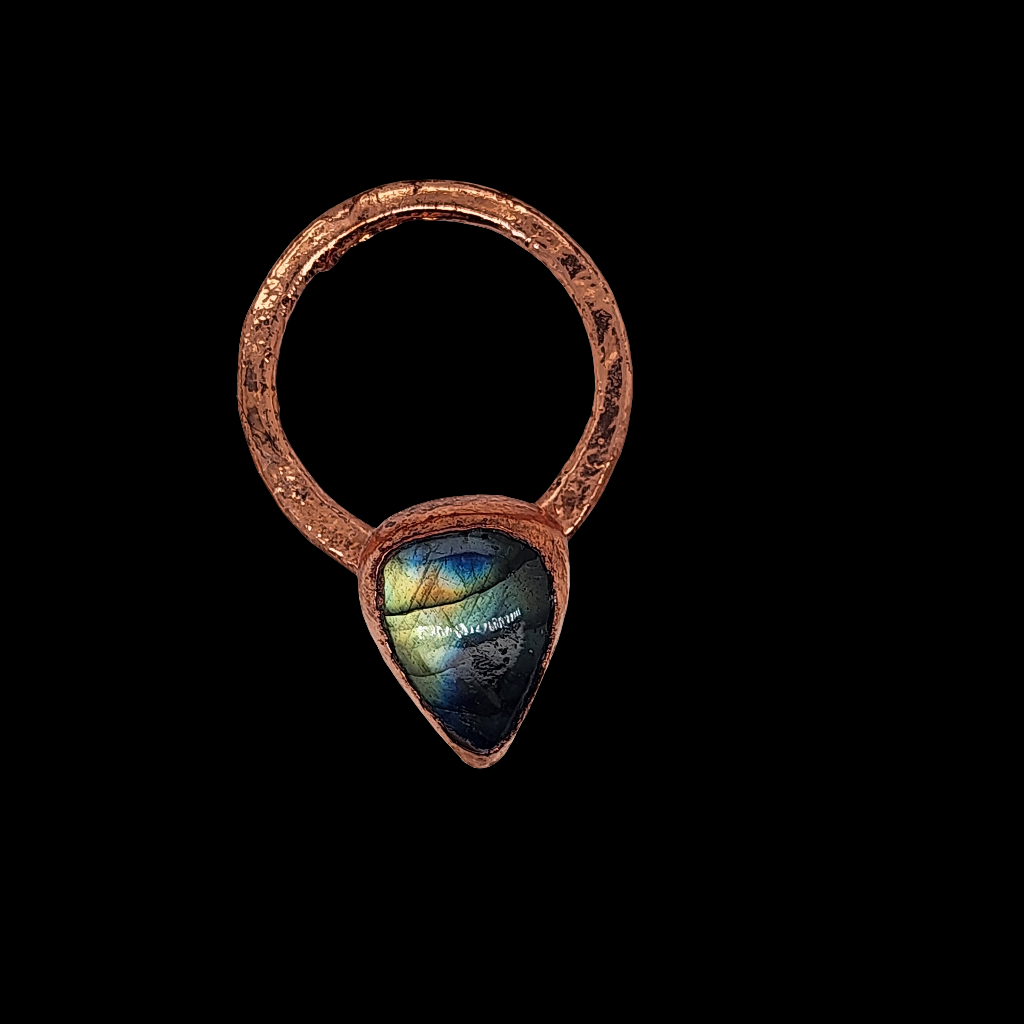 Handcrafted copper ring featuring a teardrop-shaped labradorite stone with iridescent flashes of blue and green, made using electrical alchemy, displayed against a black background.