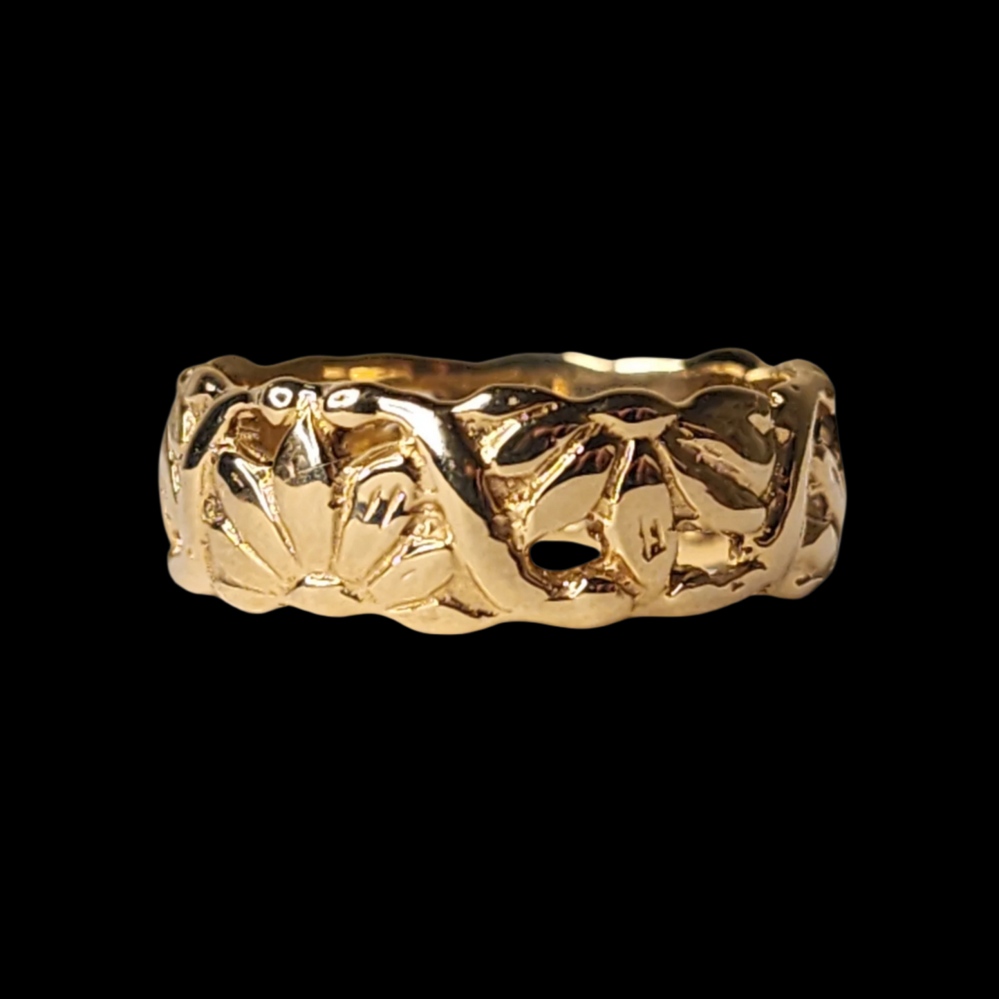 A gold ring with a textured floral pattern engraved around its surface, displayed on a black background