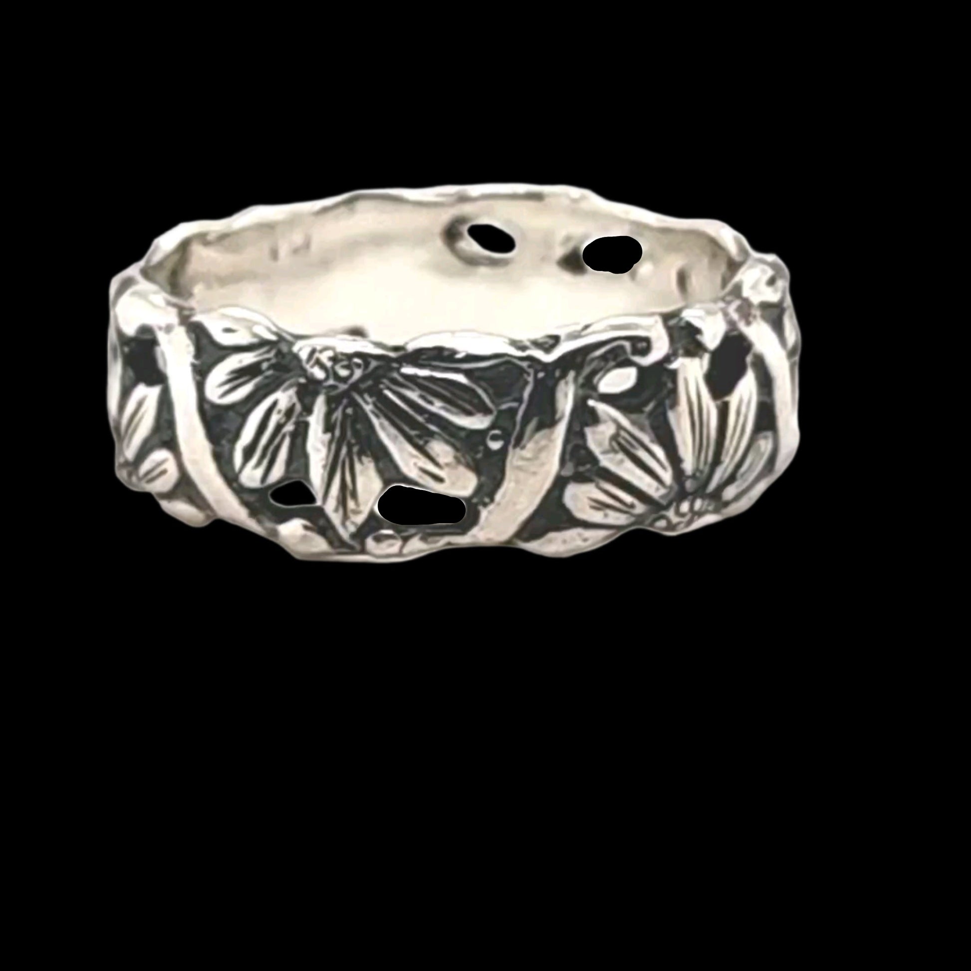 Silver ring with floral design on a black background. Halfs of Daisies alternate facing up and down representing the duality of life, love and the natural world!