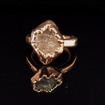 Copper ring with a large raw herkimer diamond in an electroformed setting on a black background 