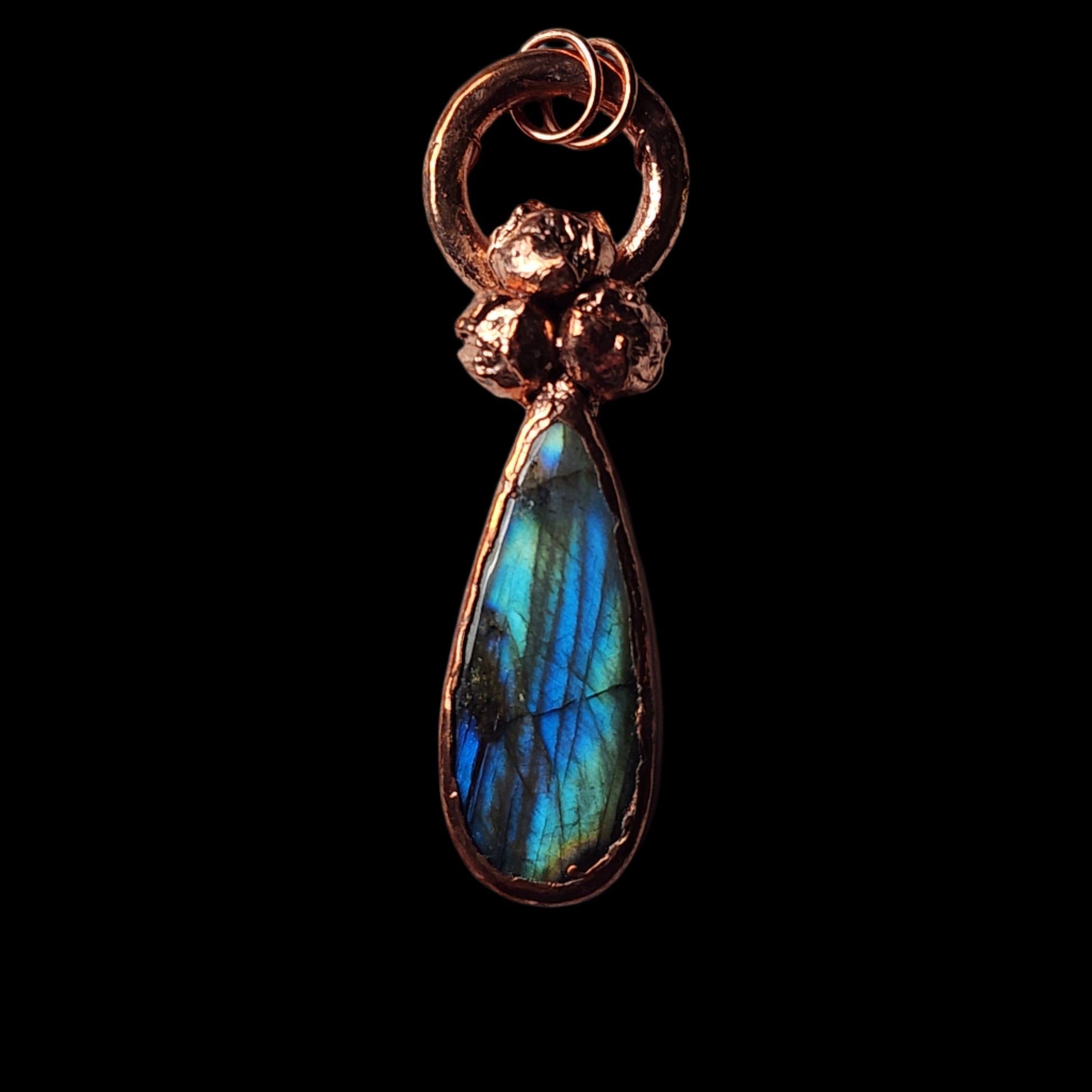 Front-facing view of a copper labradorite pendant featuring a teardrop gemstone with intricate botanical accents, reflecting light beautifully against a black background.