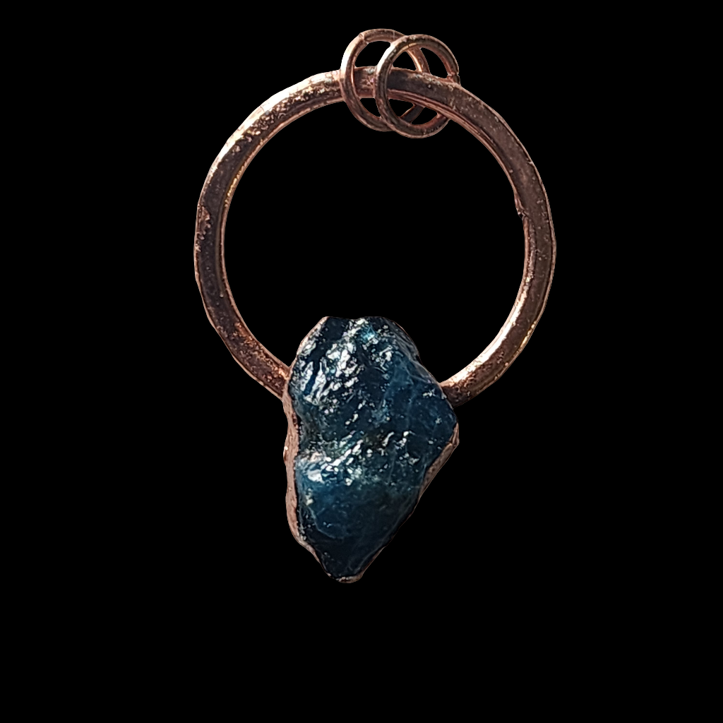 Raw blue apatite gemstone encased in handcrafted copper, forming a one-of-a-kind pendant necklace with an organic and rustic design, displayed against a black background.