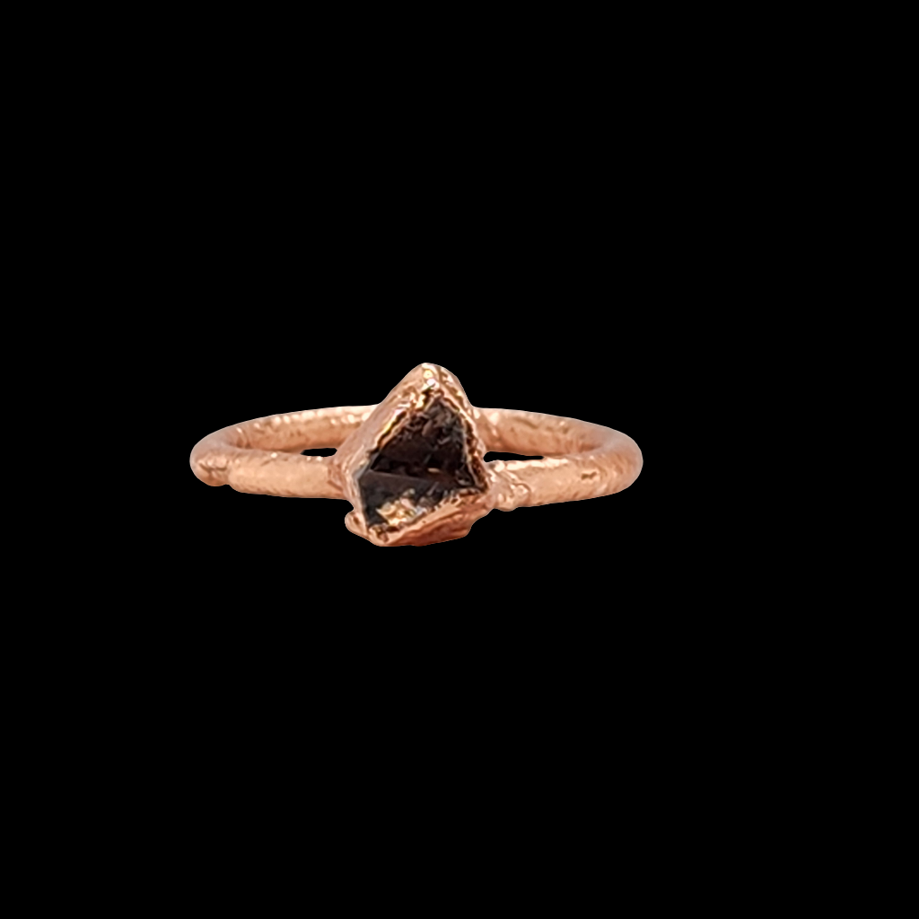 Close up of a mostly triangular shaped herkimer diamond ring encapsulated in copper. 