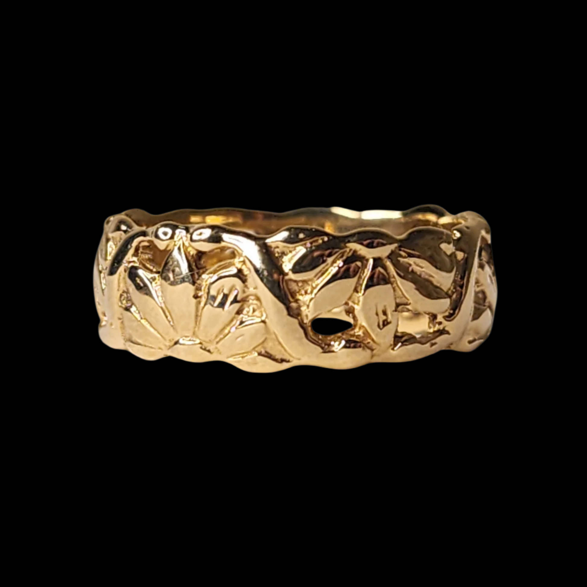 
A gold ring with a textured floral pattern engraved around its surface, displayed on a black background